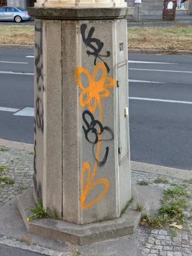 Spraypainted orange flower on a grey concrete block